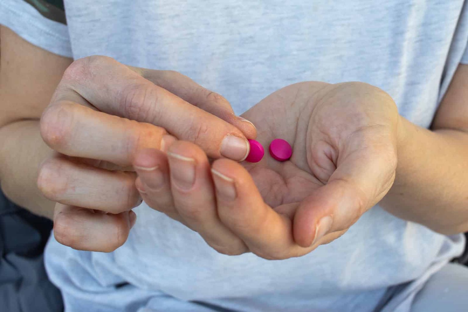 K 56 Pill: What To Know About This Pink Oxycodone Pill pink pill in hand